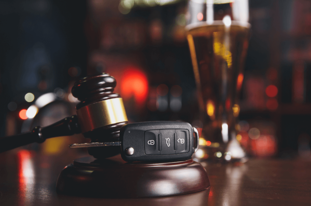 car keys laying on a bar top next to a beer