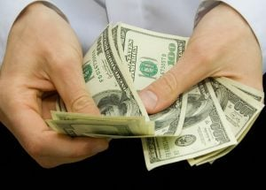 man-counting-hundred-dollar-bills_gettyimage