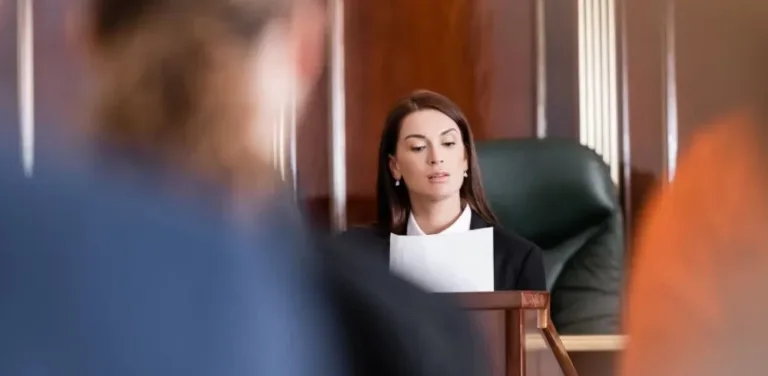 Serious courtroom scene with judge seated at bench reading legal papers