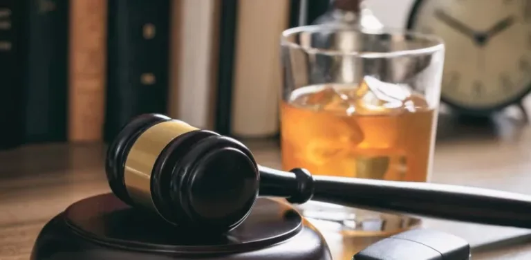 Judge's gavel beside glass of whiskey symbolizing DUI charges and drunk driving penalties