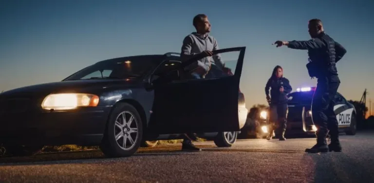 Police ordering driver out of car with patrol lights flashing at traffic stop