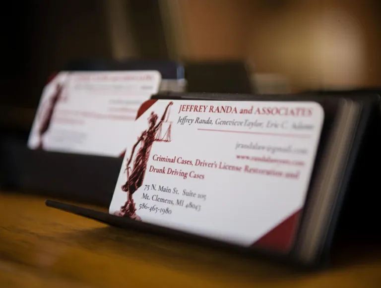 Close-up of Jeffrey Randa and Associates law firm business cards in a holder on a desk