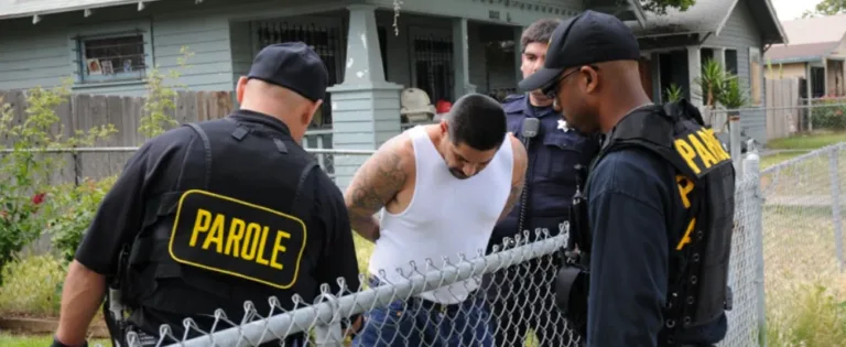 Law enforcement and parole officers taking man into custody at residential property