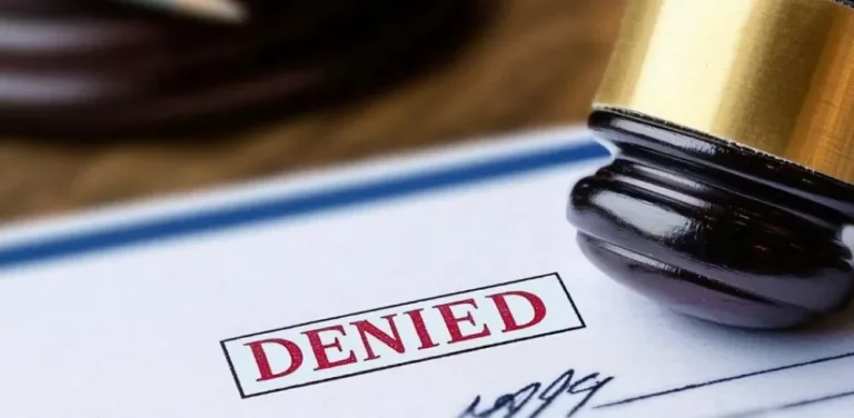 Judge’s gavel resting on a document stamped “DENIED” in bold red letters