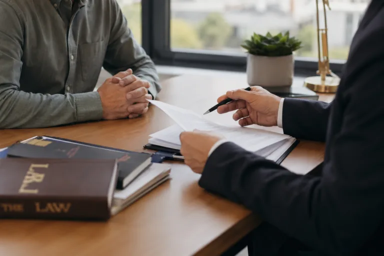 Attorney reviewing second offense DUI Michigan case documents with client at office desk