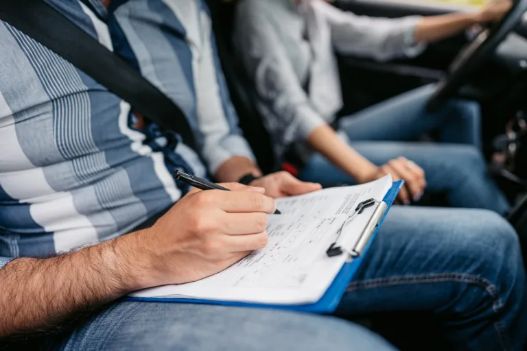 Young driving instructor grading his female student